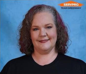 Female headshot standing in front of a blue background 